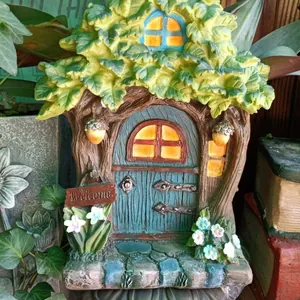 Detail of fairy house resin tree stump garden ornament with Welcome sign and blue door
