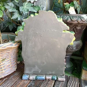 Back view of a resin fairy garden house statue with colorful cobblestone base
