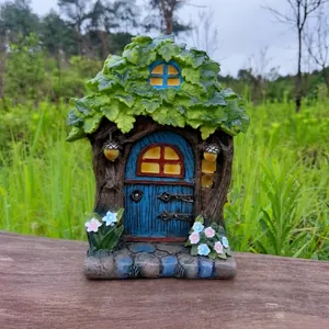Detail of resin fairy tree house ornament with Welcome sign and miniature blue door