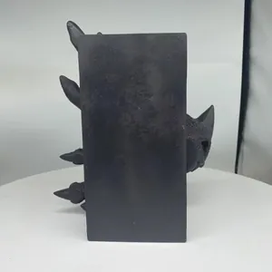 Vue détaillée d'une sculpture de dragon en résine noire mate montrant la tête et les griffes