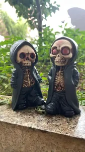 Detail of two miniature resin grim reaper figurines in black capes for Halloween decor