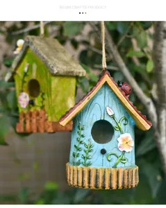 Detail of hanging resin birdhouses with 3D flower and vine patterns in a garden