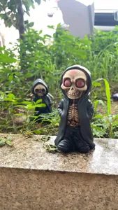 Close-up of resin skeleton grim reaper figurines in black hooded cloaks for Halloween decor