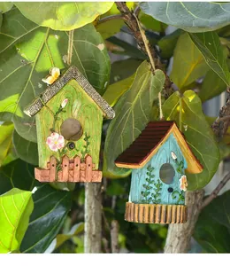 Detail of hanging birdhouse ornaments with faux wood texture and floral resin carvings