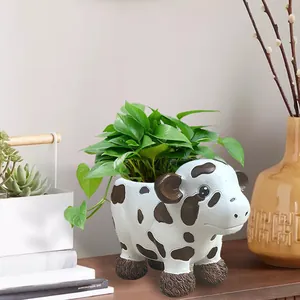 Detail view of a cute cow-shaped resin succulent planter with realistic black and white spots