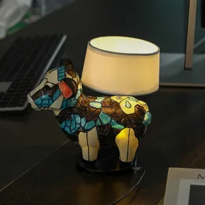 Detailed view of colorful mosaic resin cow base and cylindrical lampshade on office desk