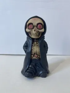Close-up of a cartoon skeleton figure in a black hooded robe with pink rib cage details