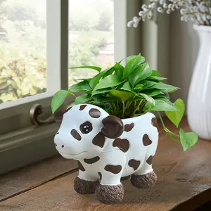 Detailed view of a cute cow-shaped resin succulent planter on a sunny windowsill