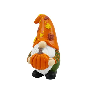 Fall gnome figurine with orange maple leaf hat holding pumpkin for harvest decoration