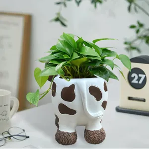 Close-up of a cow-shaped resin succulent planter featuring detailed brown spots and texture