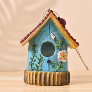 Garden resin birdhouse in sky blue with floral relief and hanging hemp rope decoration