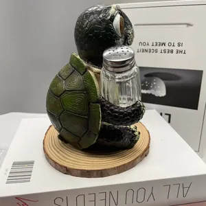 Détail d'une figurine tortue en résine tenant une salière en verre sur socle