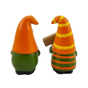 Back view of two Thanksgiving resin gnomes with hand-painted autumn maple leaf details