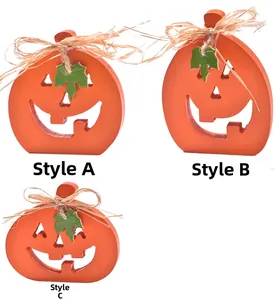Three Halloween wooden pumpkin ornaments with raffia bows and green leaf details