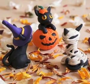 Detail of resin Halloween cat figurines including witch pumpkin and mummy designs