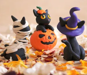 Detailed view of Halloween resin black cat figurines with mummy, pumpkin and witch themes