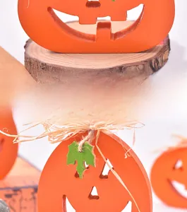 Detail of wooden Halloween pumpkin decor with orange hollow carving and rustic hay bow