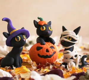 Detailed view of Halloween resin black cat figurines with witch hat and pumpkin accents
