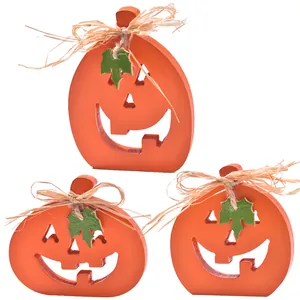 Set of three orange wooden Jack-o'-lantern pumpkin ornaments with rustic raffia bows