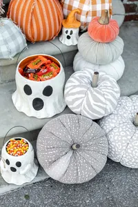 Detailed arrangement of patterned fabric pumpkins and ghost-shaped Halloween treat buckets