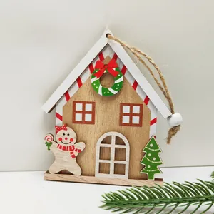 Detail of wooden gingerbread house ornament with a cute gingerbread man and green tree