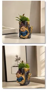 Dettaglio di un vaso per piante grasse in resina a forma di tronco con nano da giardino