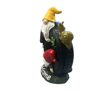 Garden welcome sign with gnome figurines and a snail on a resin tire outdoor statue