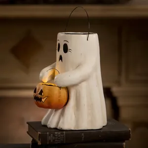 Halloween ghost with glowing pumpkin lantern on vintage books, warm LED light decor