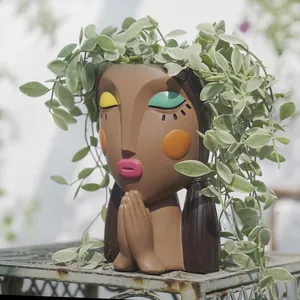 Creative girl face resin planter with closed eyes in a garden setting for home decor