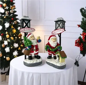 Close-up of Santa Claus resin figurines with Welcome lamp posts and glowing festive lights