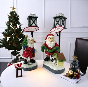 Close-up of resin Santa Claus figurines with a Welcome sign and lamp post decor