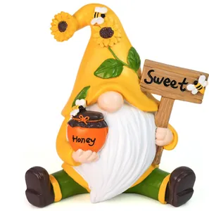 Detail of bee gnome statue holding Honey jar and Sweet sign with sunflower accents