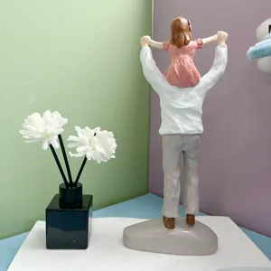 Detail of hand-painted resin sculpture showing a father carrying daughter on his back
