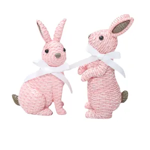 Pink woven resin rabbit ornaments with white ribbon bows for garden and home decor