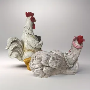 Close-up of rooster and hen figurines with detailed resin feathers and pearl necklace decor