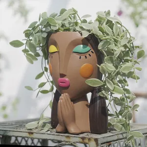Artistic girl face resin planter pot with closed eyes and green plants for garden decor