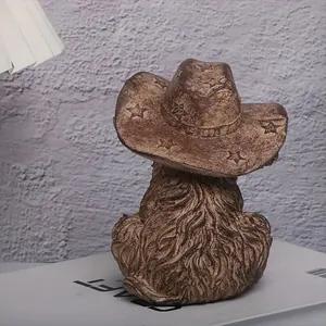 Dettaglio macro della statuetta rustica di mucca delle Highland con cappello cowboy