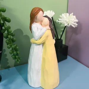 Vue détaillée d'une figurine en résine montrant deux sœurs s'enlaçant tendrement