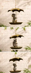 Detalle de comederos para pájaros en bronce con perro, ardilla y gato con sombrillas