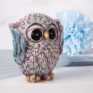 Detailed macro view of resin owl figurines with feathered texture and gold accents
