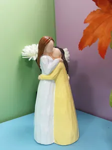 Détail d'une statue en résine minimaliste montrant deux femmes avec texture en bois gravée