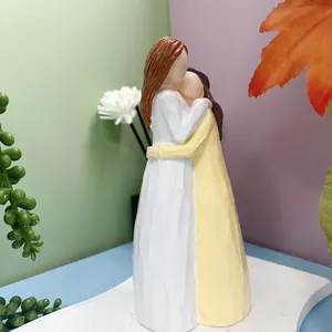 Détail d'une sculpture minimaliste en résine montrant deux amies qui s'enlacent