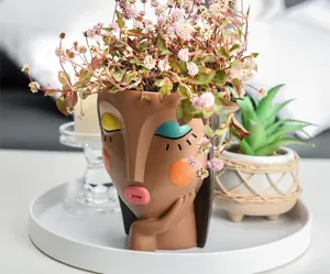 Artistic resin girl head planter in brown skin tone with colorful makeup for home decor
