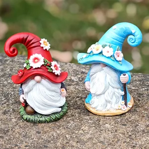 Detail of Christmas resin gnomes with floral hats and white beards for garden decor