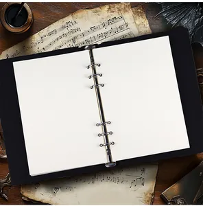Détail de la reliure en métal à 6 trous et des pages blanches d'un carnet vintage