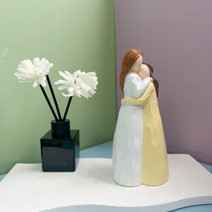 Détail d'une figurine en résine montrant deux filles qui s'enlacent avec une texture de bois