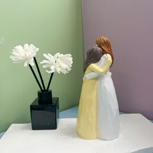 Vue détaillée de deux figurines de femmes s'enlaçant en résine avec une texture sculptée main