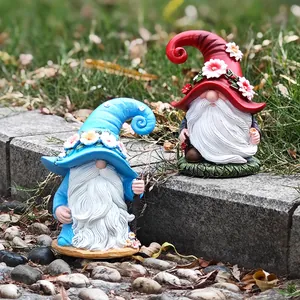 Detailed view of two garden gnome resin statues with colorful hats on garden stone steps