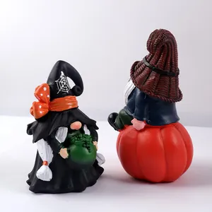 Detail of handcrafted Halloween garden gnomes with witch hat and pumpkin decorations