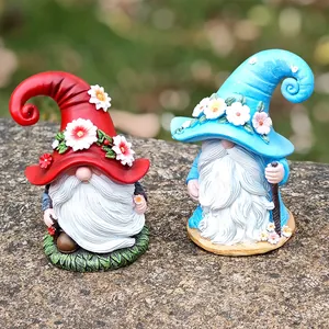 Pair of outdoor Christmas garden gnomes figurines with white beards and resin flowers